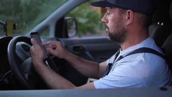 Bearded Delivery Man Choosing Route Before Driving alt