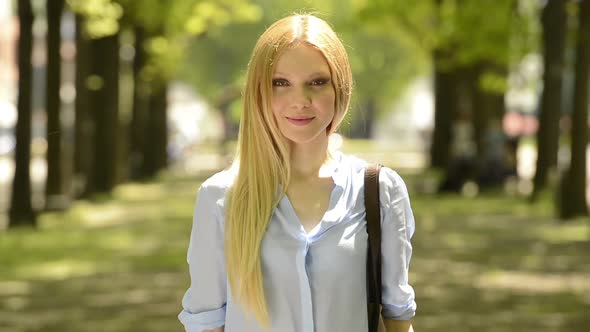 Young Beautiful Blonde Girl Portrait in Summer Day at Urban City Park alt