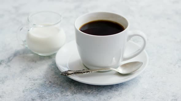 Cup of Coffee and Pitcher of Milk alt