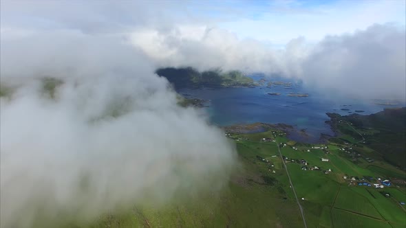 Fast moving clouds on green mountain slope, aerial view alt