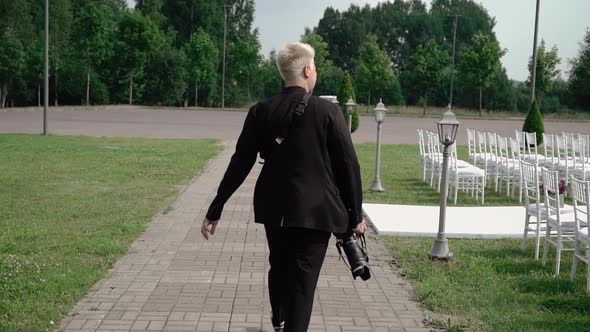 Photographer at Wedding Ceremony with DSLR Photo Camera with a Telephoto Lens alt