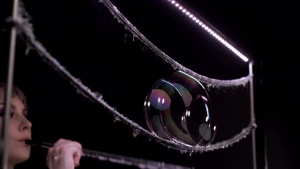 Closeup Woman Does Tricks with Soap Bubbles She Blows Few Bubbles in the Form of Pyramid alt