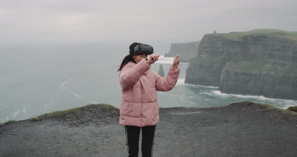 On the Rooftop of the Cliffs Young Lady Wearing VR Glasses alt