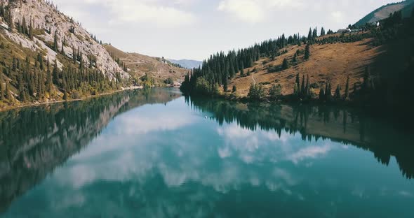Beautiful landscape of mountain lake, Emerald water surrounded by coniferous forest, autumn grass alt