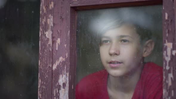 Boy at Home Look at the Window and Puts on a Mask Before Going Outside alt
