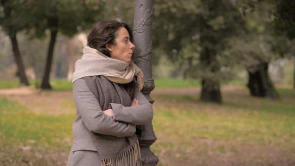 Angry nervous young woman waiting for her later comer boyfriend in the park alt