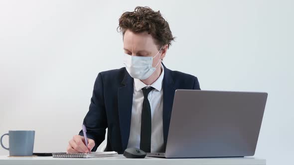 Despairing Businessman in Face Mask Counts Losses From Epidemic COVID-19