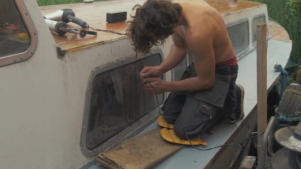 Scraping old silicone sealant from windows of old timber boat alt