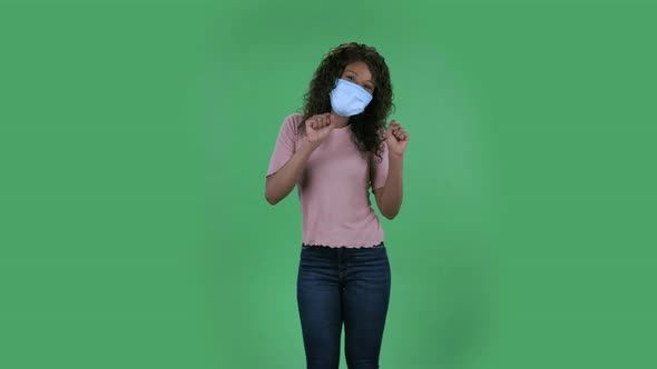 Portrait of Beautiful African American Young Woman in Medical Mask Is Looking Straight and Is alt