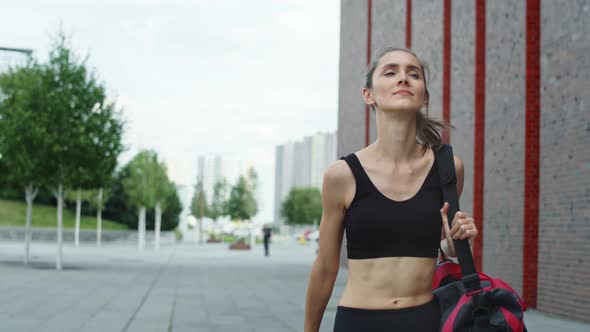 Video of woman walking in a training outfit in the city. Shot with RED helium camera in 8K.  alt