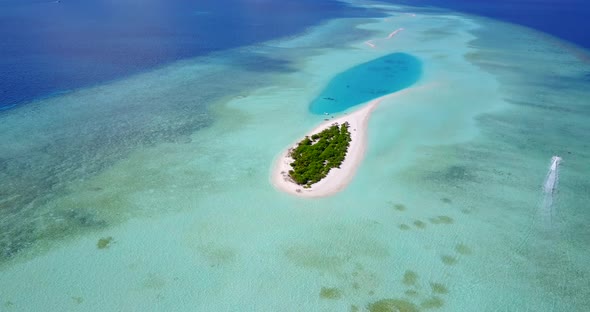 Daytime aerial tourism shot of a white sandy paradise beach and aqua blue ocean background  alt