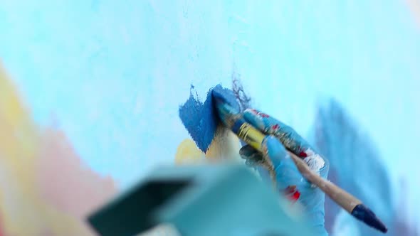 The Artist Paints the Wall with Brush