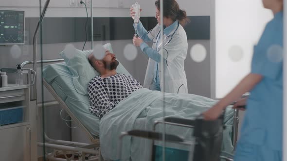 Medical Team Monitoring Patient Vital Checking Heart Rate Helping with Fluids alt