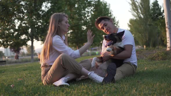 Lovely couple with their dog having fun in the park alt
