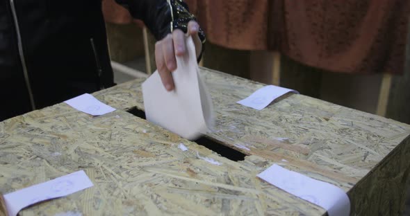 Unidentifiable person casting a ballot during elections