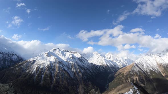 Timelapsewide Angle High Above the Gorge Quickly Float Clouds Covering the Snowcapped Peaks of High alt