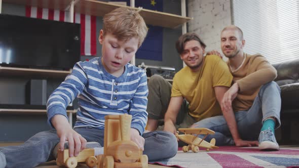 Boy with Two Fathers Playing with Toys alt