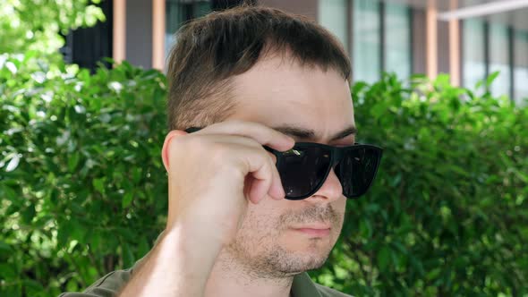 Male with Inflamed and Affected Conjunctivitis Eye Looks Over Glasses alt