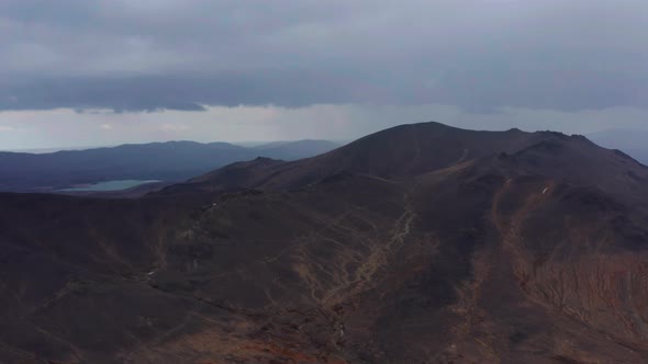 Aerial View of the Mountain Against the Background of Clouds and a Mountain Range alt