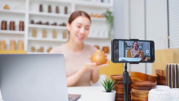 Asian beautiful woman sell vase product online live streaming at home. alt