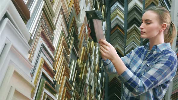 Young Female Client Looking for a Frame in Special Store alt