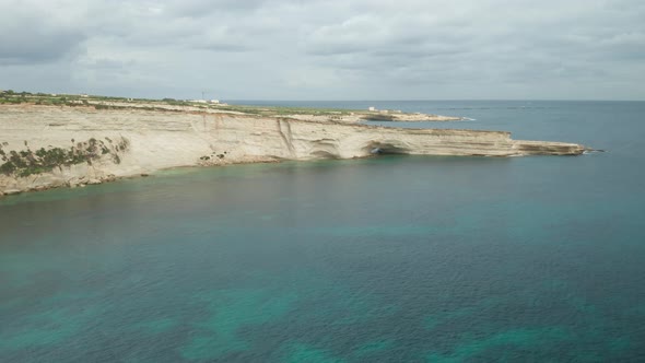 AERIAL: Ta Kalanka Sea Cave in Il-Hofra l-Kbira Bay During Winter in Malta