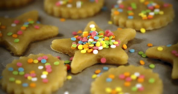 Women's Hands are Sprinkled with Multicolored Starshaped Shortbread Cookies
