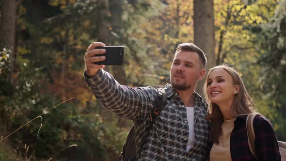 Travellers Bloggers are Filming Themselves During Hike in Forest Taking Selfie By Smartphone alt