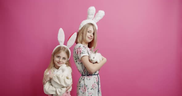 Cute Girls With Rabbit Ears Playing with the Rabbit on an Isolated Background alt
