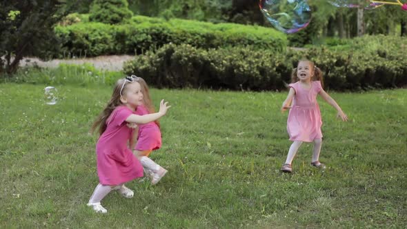 Happy Little Girls Playing in Garden and Playing Bubbles