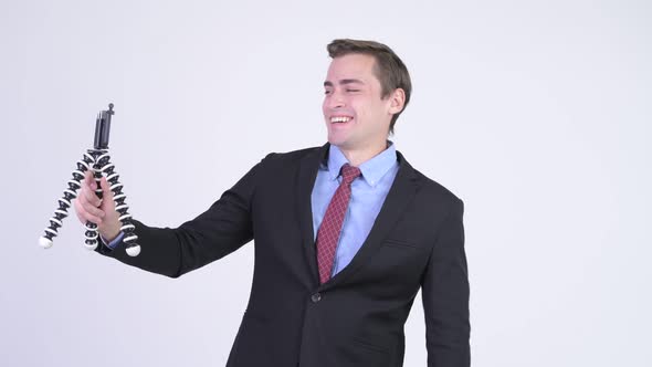 Young Happy Handsome Businessman Vlogging with Phone alt