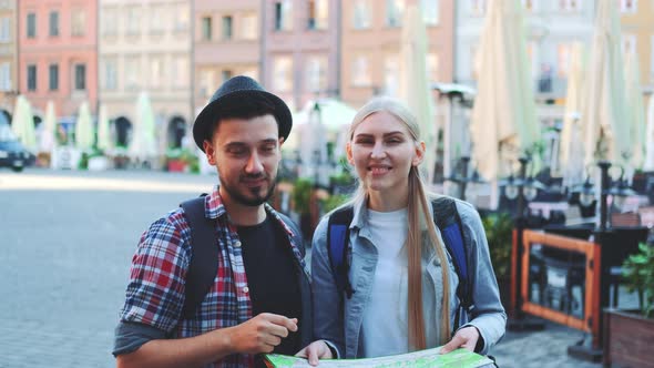 Tourists Checking Map and Then Smiling To the Camera alt