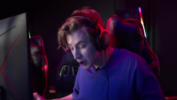 A Cute Gamer Plays an Online Game Worries About His Teammates and Encourages Them Slow Motion alt