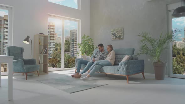 Couple connecting with their laptop alt