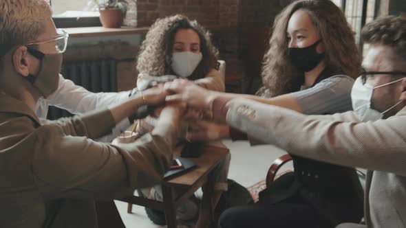 Happy Team of Coworkers with Hands Together in Middle alt