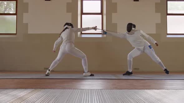 Fencer athletes during a fencing training in a gym alt