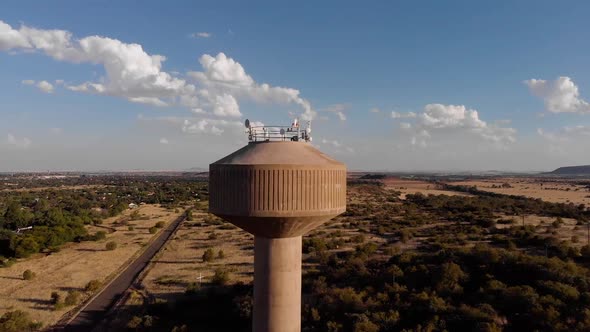 DRONE Circling Shot of a Broadcast Tower in a Rural Area on a Sunny Day alt