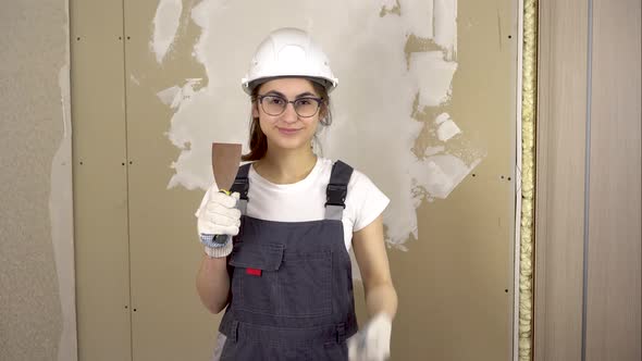 A Builder with a Spatula in His Hand Looks at the Camera and Shows the Class and Smiles alt