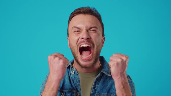 Angry Young Man Shouting Against Blue Background