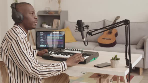 African Man Creating Music Using Home M-audio Keystation alt