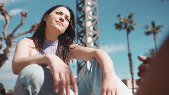 Handsome sunny woman talking with her friend and gesturing alt
