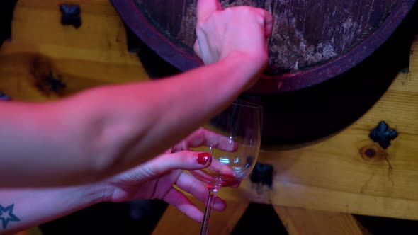 Young Female Sommelier Extracts the Wine From the Barrel