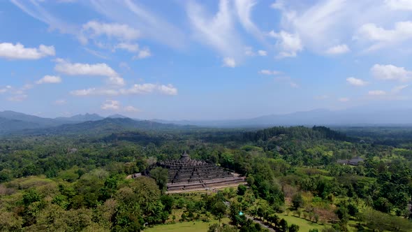 Iconic Buddhist temple Borobudur, Indonesia surrounded by tropical forest aerial alt