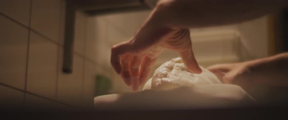 Chef slowly kneading traditional pizza dough in a restaurant kitchen. Close up, slow motion alt