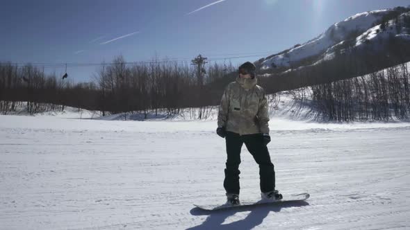 Snowboarder Enjoying a Mountain Ride at a Ski Resort on a Sunny Day