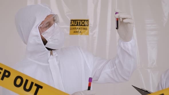 A Doctor in a Protective Suit with a Blood Test for Coronavirus in the Hospital alt