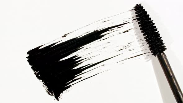 Macro Shot and Slow Motion of a Black Mascara Isolated on White Background alt