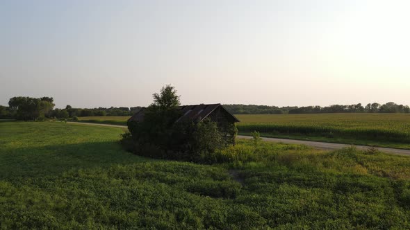 Aerial footage lonely old shack in Minnesota during summer time, farms, country side, fields alt