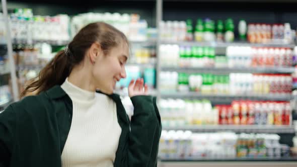 Happy Young Girl Funny Dancing Between Shelves in Supermarket alt