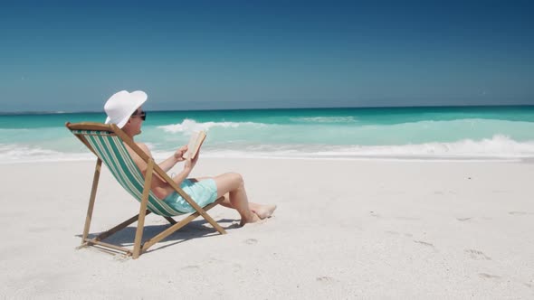 Man reading a book on the beach alt